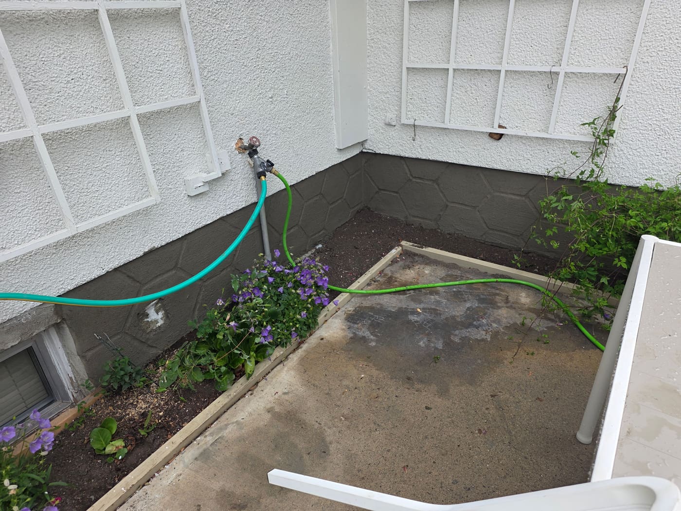 Finished parging with a hexagon geometric stone pattern on a Calgary foundation wall