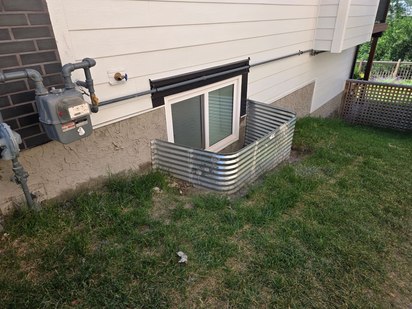 Rejuvenated parging around a window well on a Calgary home