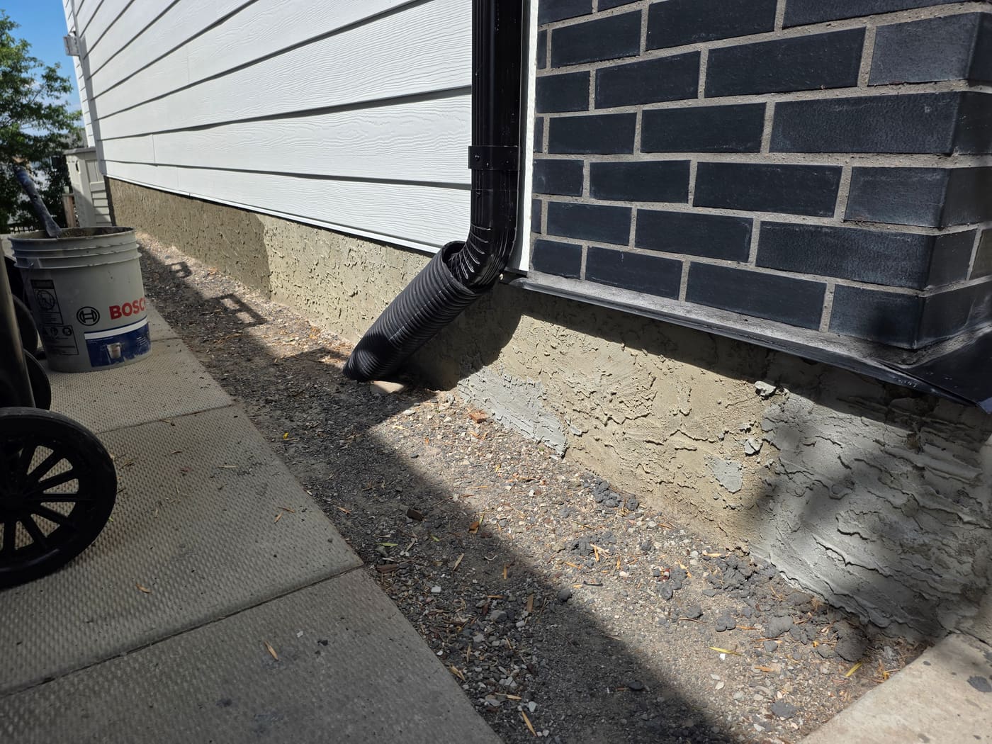 Calgary foundation wall with patch repairs and flaking parging before rejuvenation